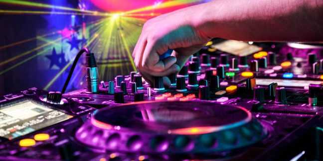 disco 40381728 - dj mixes the track in the nightclub at party. in the background laser light show